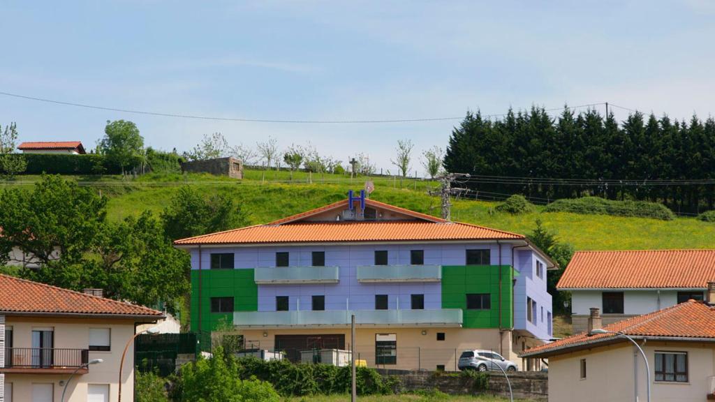 um edifício com telhado vermelho e verde em Aginaga Hotela em Usúrbil