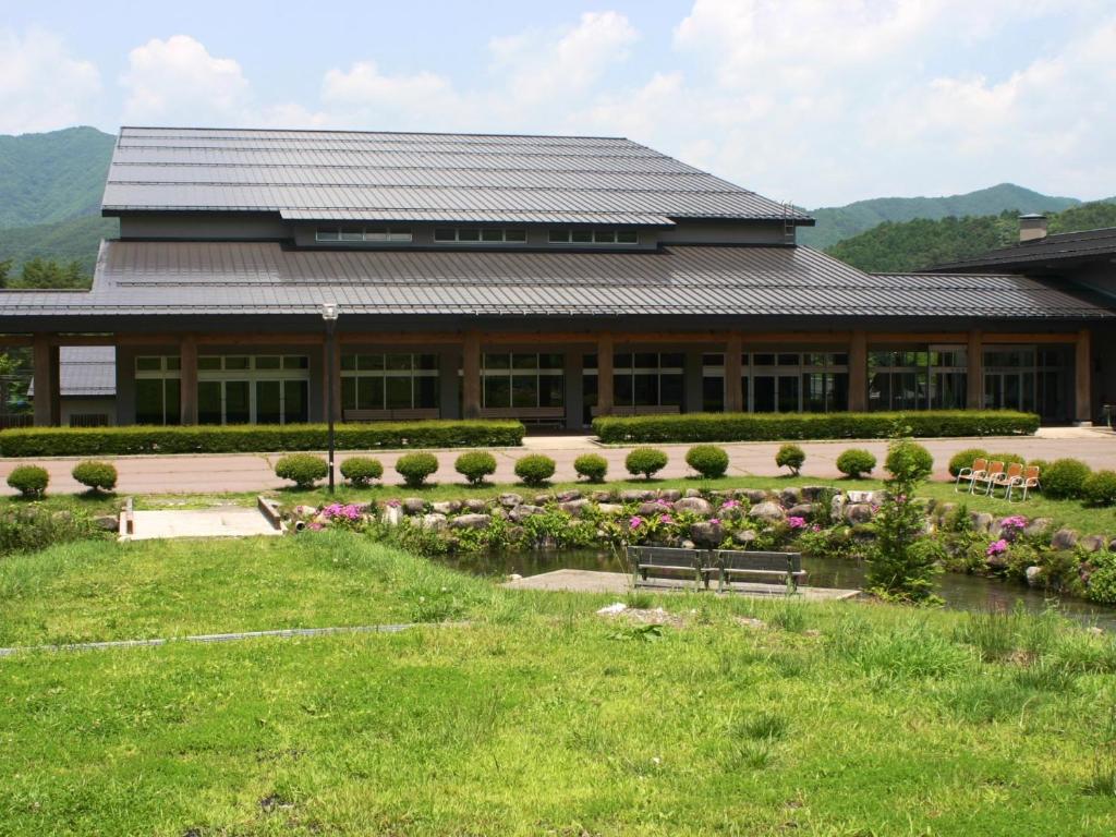 a building with a bench and flowers in front of it at Komao in Kiso