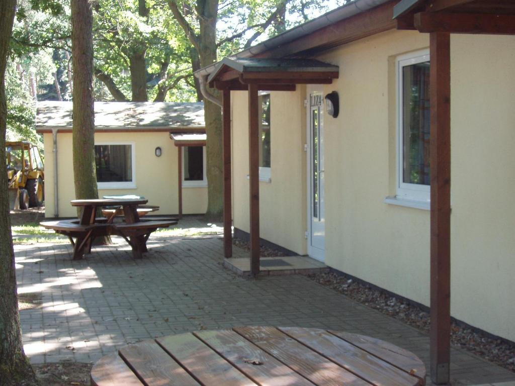 eine Terrasse mit einem Picknicktisch und ein Haus in der Unterkunft Hostel Schweriner See in Retgendorf