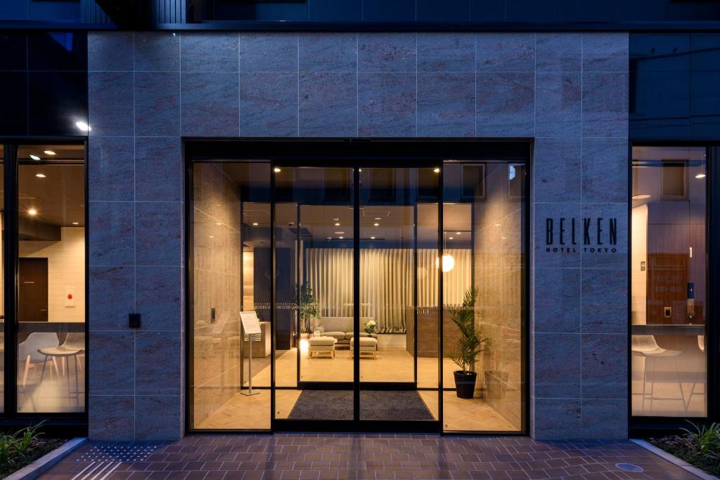 una entrada a un edificio con puertas de cristal en Belken Hotel Tokyo, en Tokio