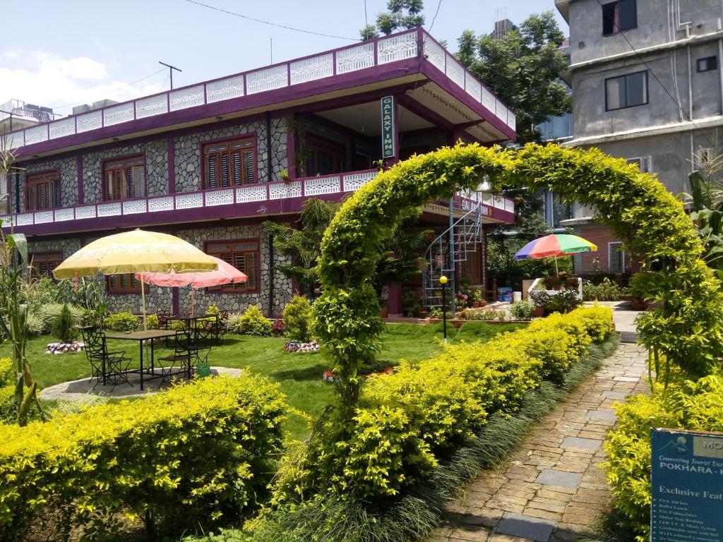 um jardim com um arco em frente a um edifício em Galaxy Inn Guest House em Pokhara