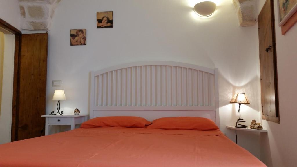 1 dormitorio con 1 cama grande de color naranja y 2 lámparas en Il Rifugio Sul Mare en Monopoli