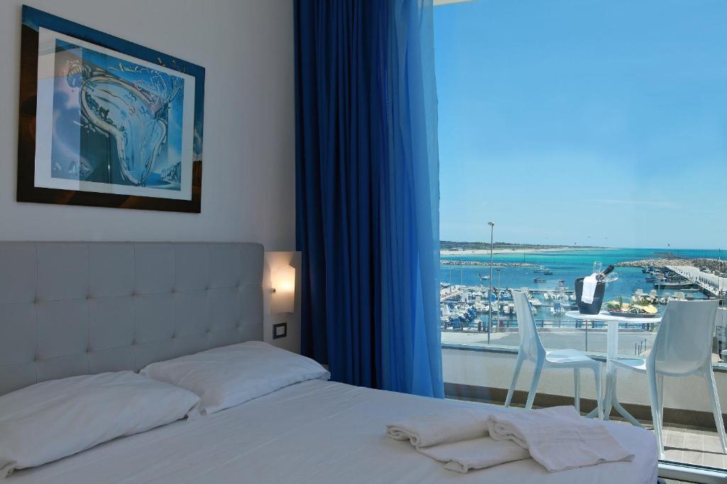 a bedroom with a bed and a window with a view at Nauticus Guest Room in Torre San Giovanni Ugento