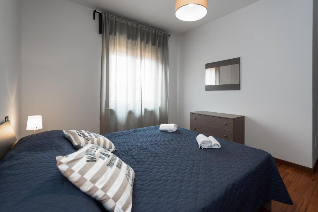 a bedroom with a blue bed with two pillows at Ortaglia B2 in Torri del Benaco