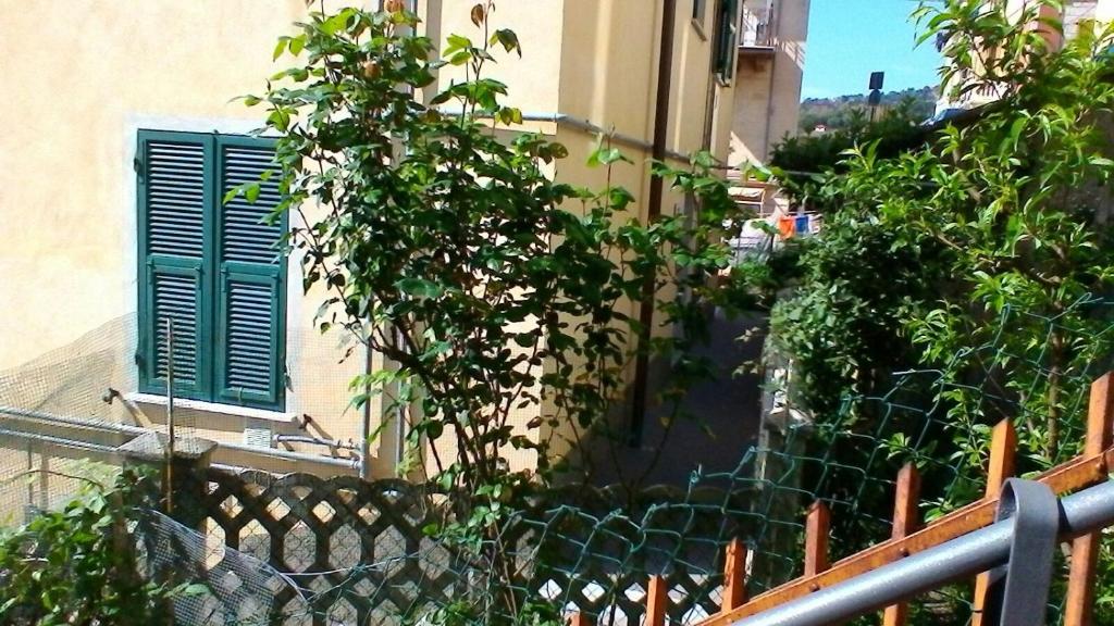 un edificio con una finestra verde e una recinzione di Profumo di casa a La Spezia