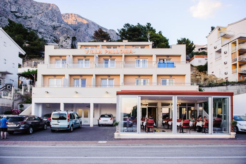 ein Gebäude mit Autos auf einem Parkplatz in der Unterkunft Villa Palloma in Baška Voda