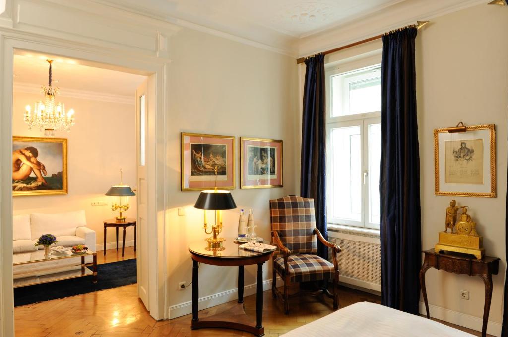 a living room with a table and a window at Boutique Hotel Splendid in Munich