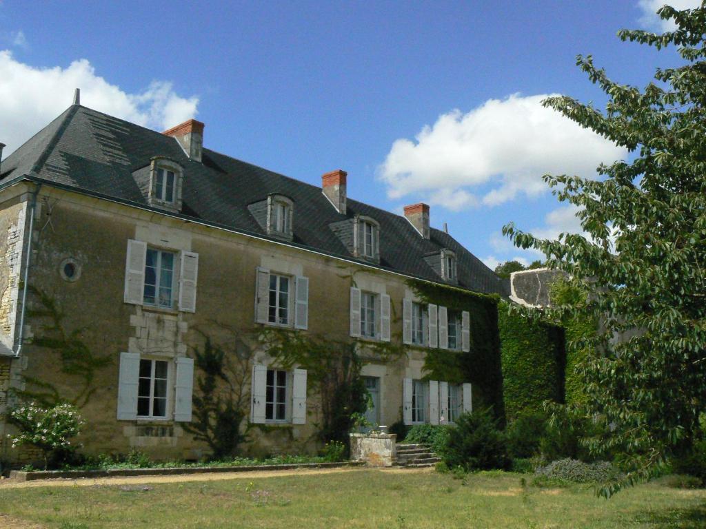 ein großes Backsteingebäude mit schwarzem Dach in der Unterkunft Manoir De Vilaines in Varennes