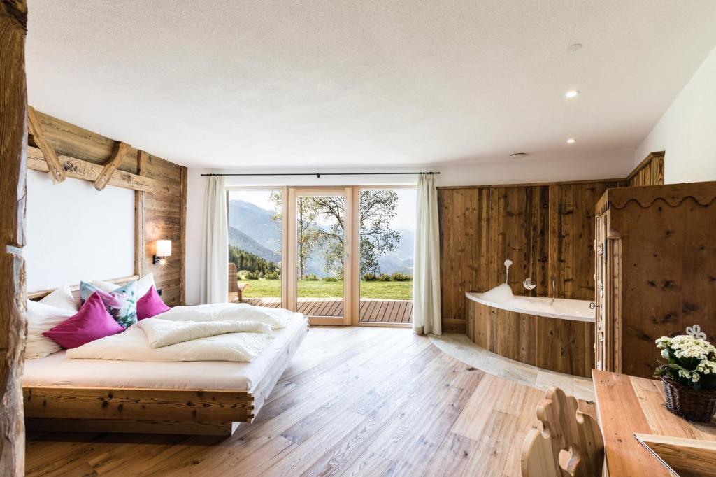 a bedroom with a bed and a bath tub at Ahner Berghof in Rodengo