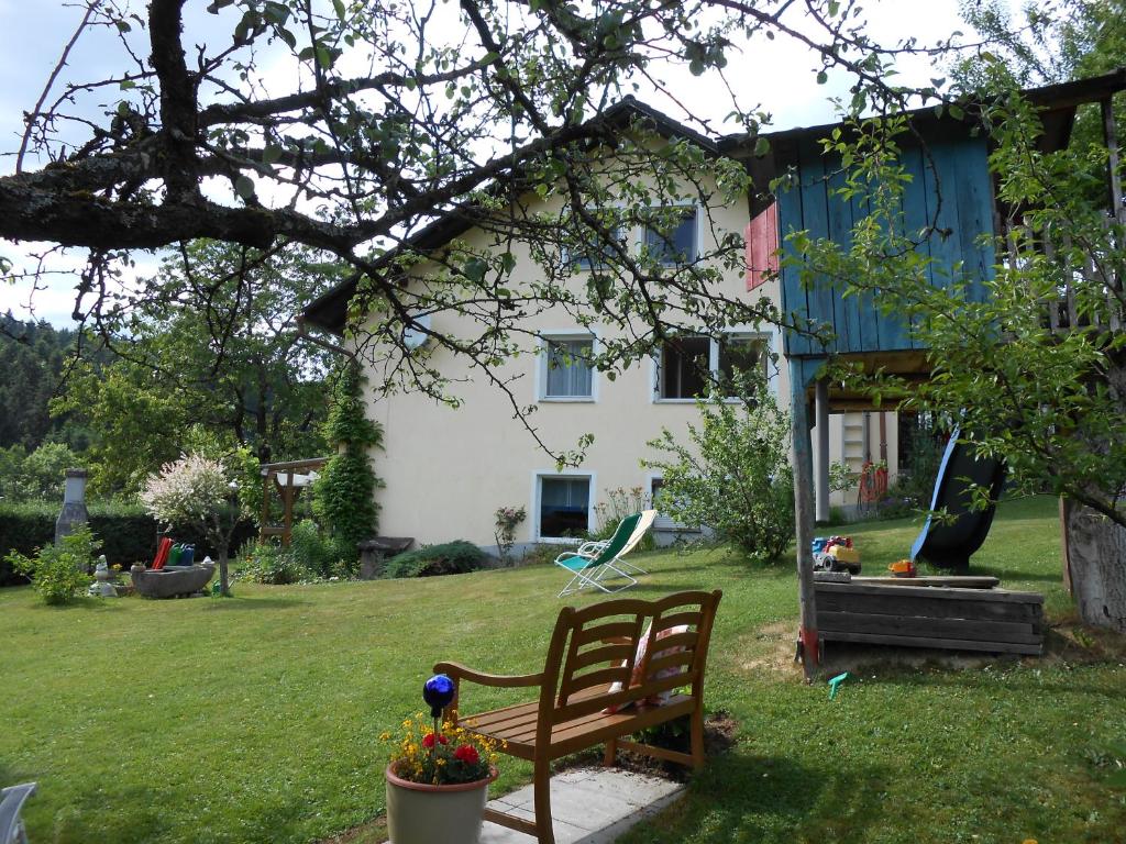 a yard with a bench in front of a house at Ferienwohnung Groß in Grafenau