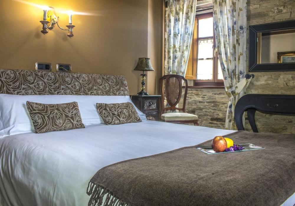 um quarto com uma cama com um prato de fruta em Alén do Mis - Hotel Rural em Foz