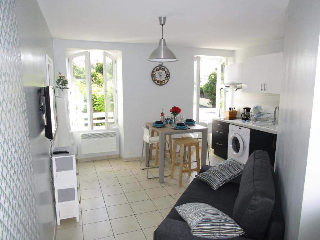 a living room with a couch and a kitchen at Agréable T2 à Bidart, centre bourg & plages à pied in Bidart