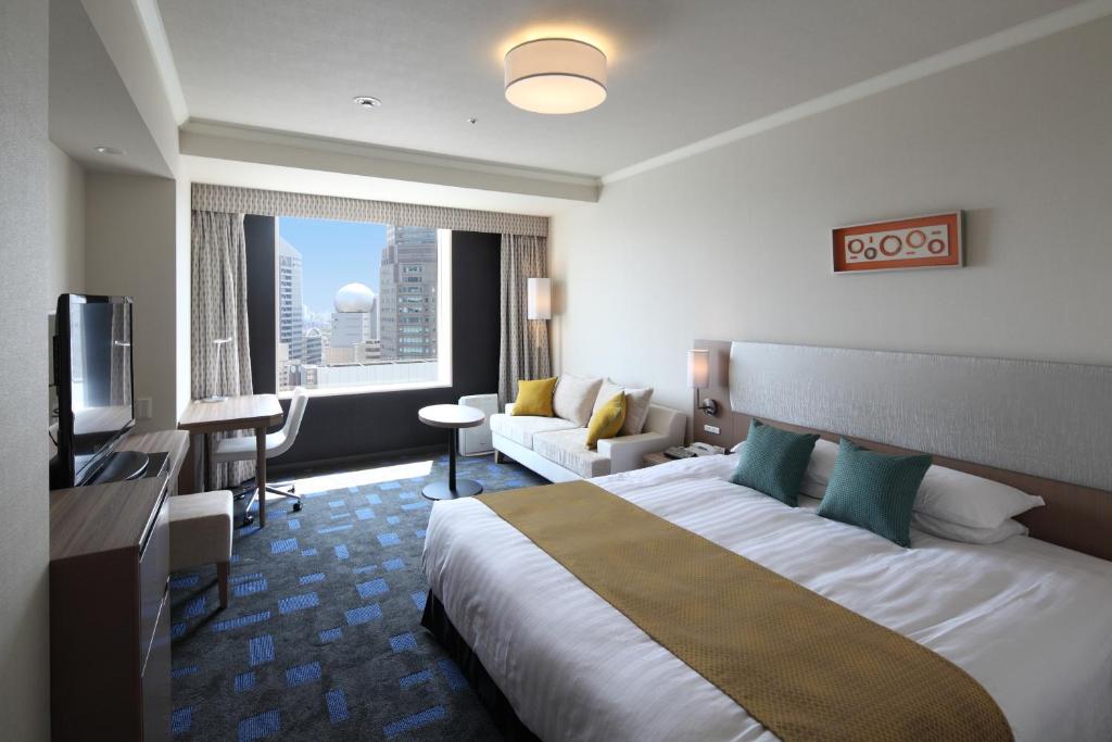a hotel room with a large bed and a couch at Shibuya Excel Hotel Tokyu in Tokyo