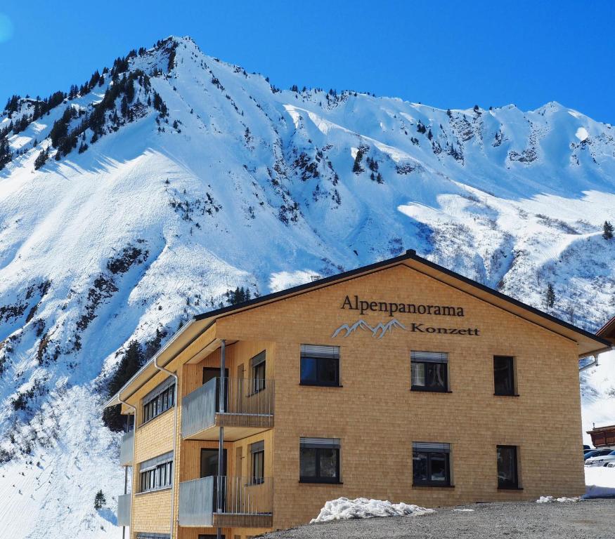 ein Gebäude vor einem schneebedeckten Berg in der Unterkunft Alpenpanorama Konzett in Faschina