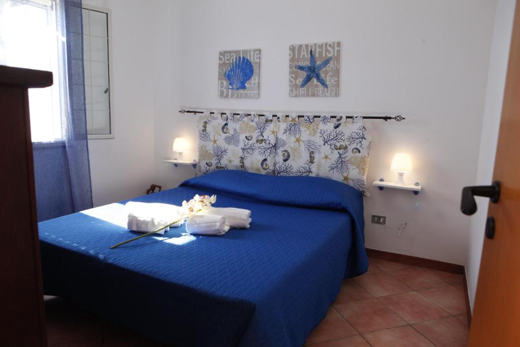 カステッランマーレ・デル・ゴルフォにあるCorallo Bluのベッドルーム1室(ブルーベッド1台、タオル付)