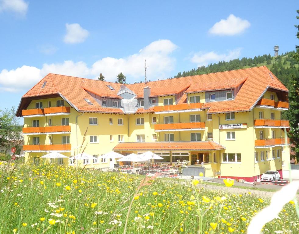 um grande edifício amarelo com um telhado laranja em Burg Hotel Feldberg em Feldberg