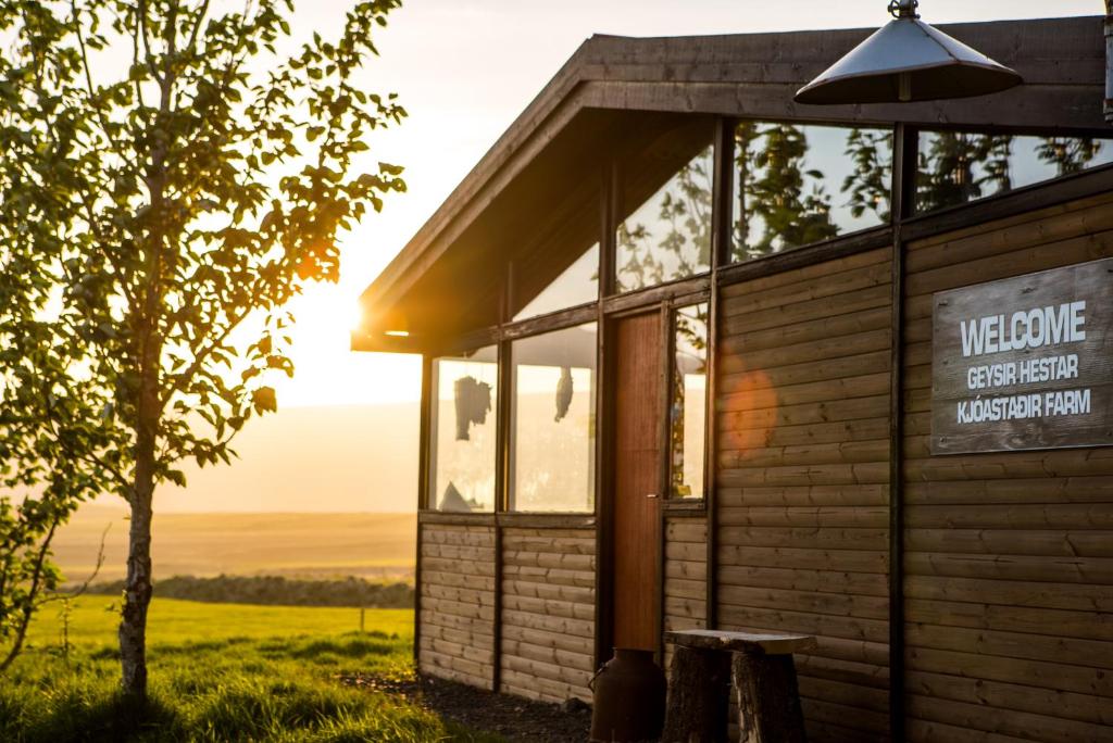 um edifício com o pôr-do-sol ao fundo em Geysir Hestar em Haukadalur