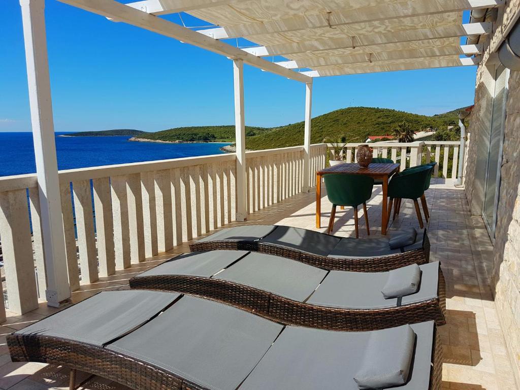 balcón con mesa, sillas y vistas al océano en Apartment MORE Island Vis, en Vis