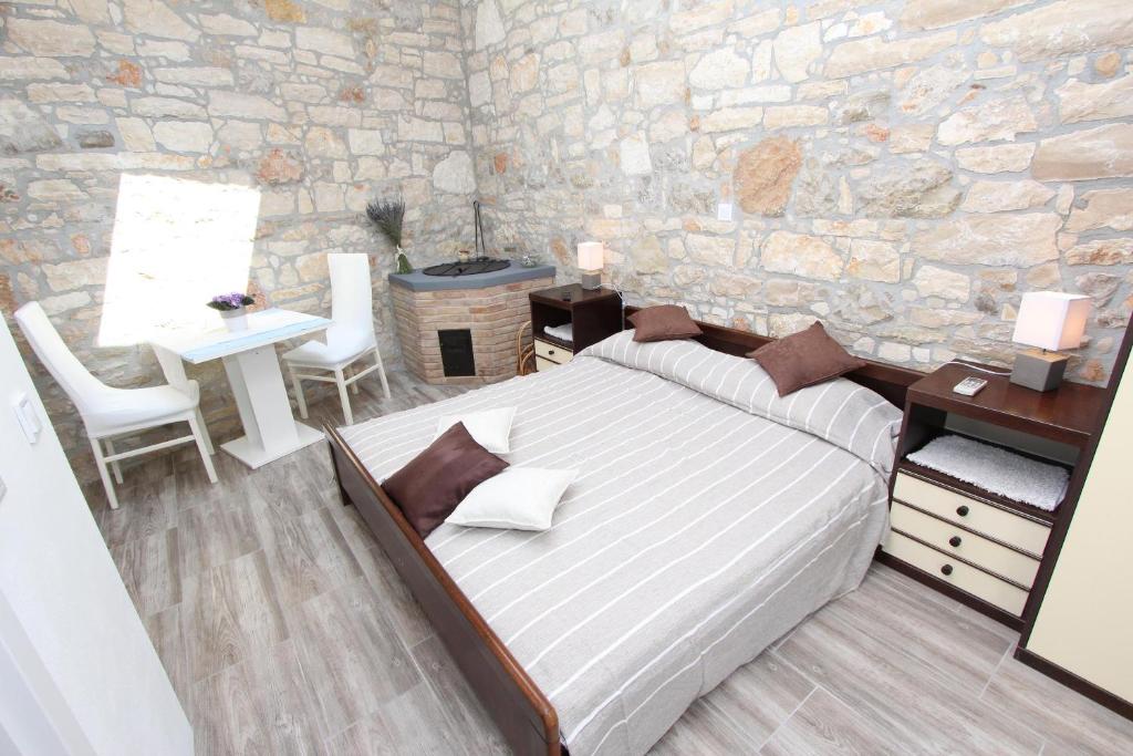 a bedroom with a bed and a stone wall at Apartments Santin in Rovinj