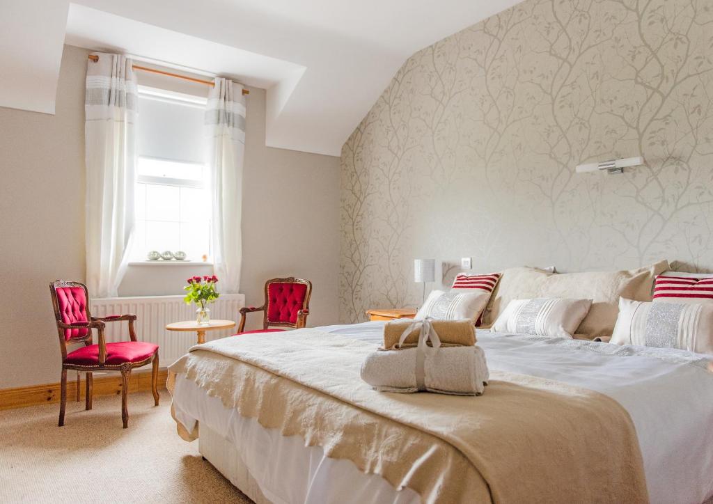 a bedroom with a large bed and two red chairs at Melvin Country House in Garrison