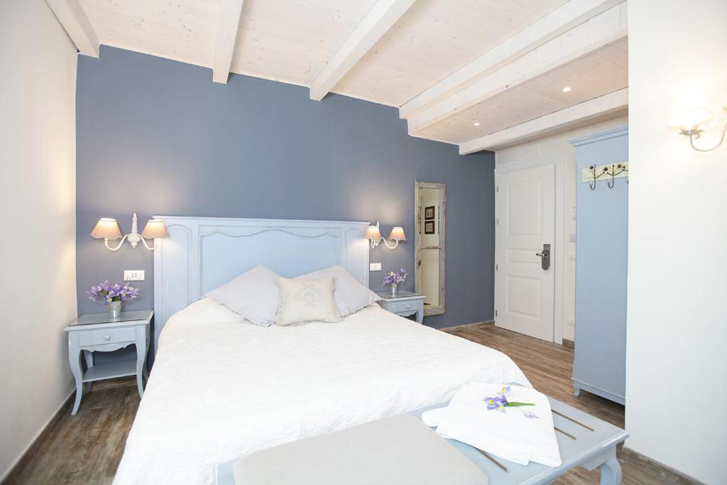 una camera con letto bianco e pareti blu di Villa Valentina a Levanto