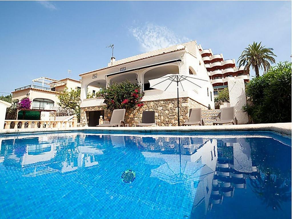 una piscina con sillas y una casa en Villa Caleta 0901, en Calpe