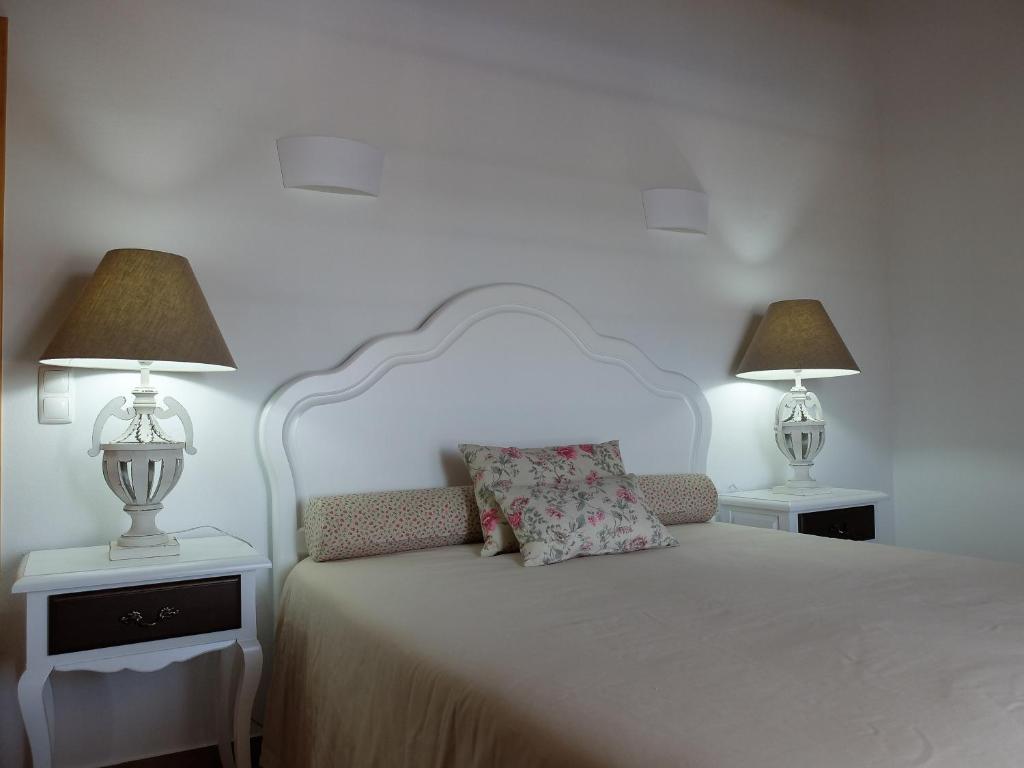 una camera con un letto bianco e 2 lampade di Vales do Alentejo a Bicos