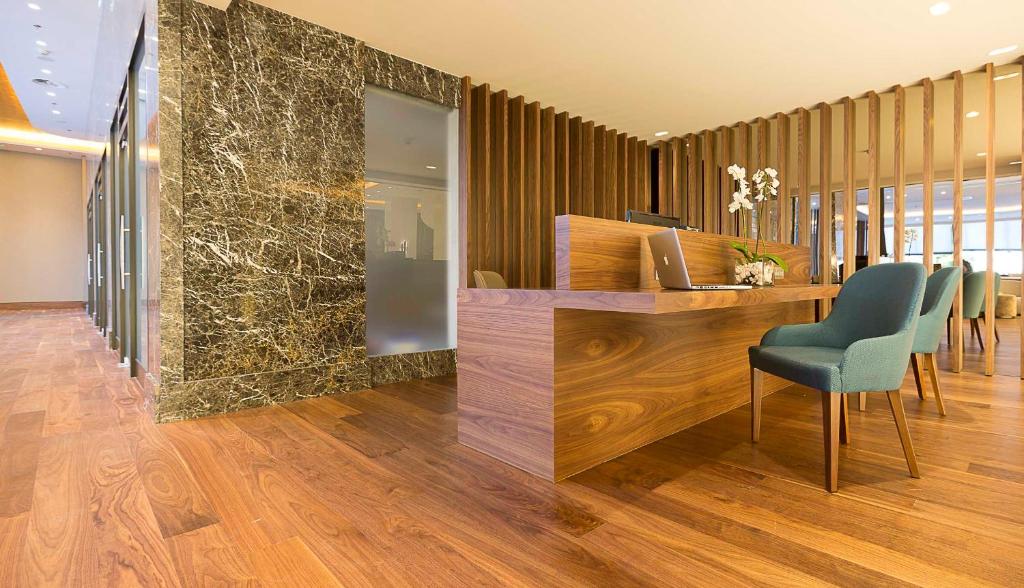 a lobby with a desk and chairs in a room at Makedonia Palace in Thessaloniki
