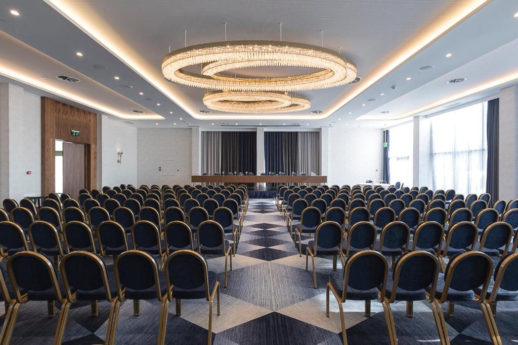 a conference room with chairs and a chandelier at Makedonia Palace in Thessaloniki
