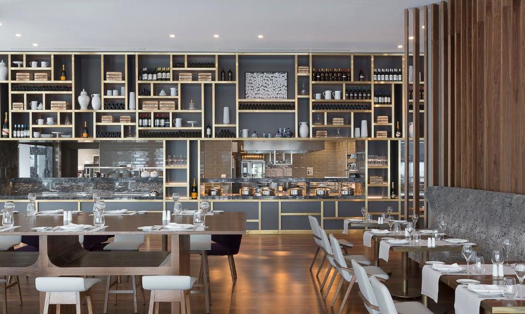 a dining room with tables and chairs and a kitchen at Makedonia Palace in Thessaloniki