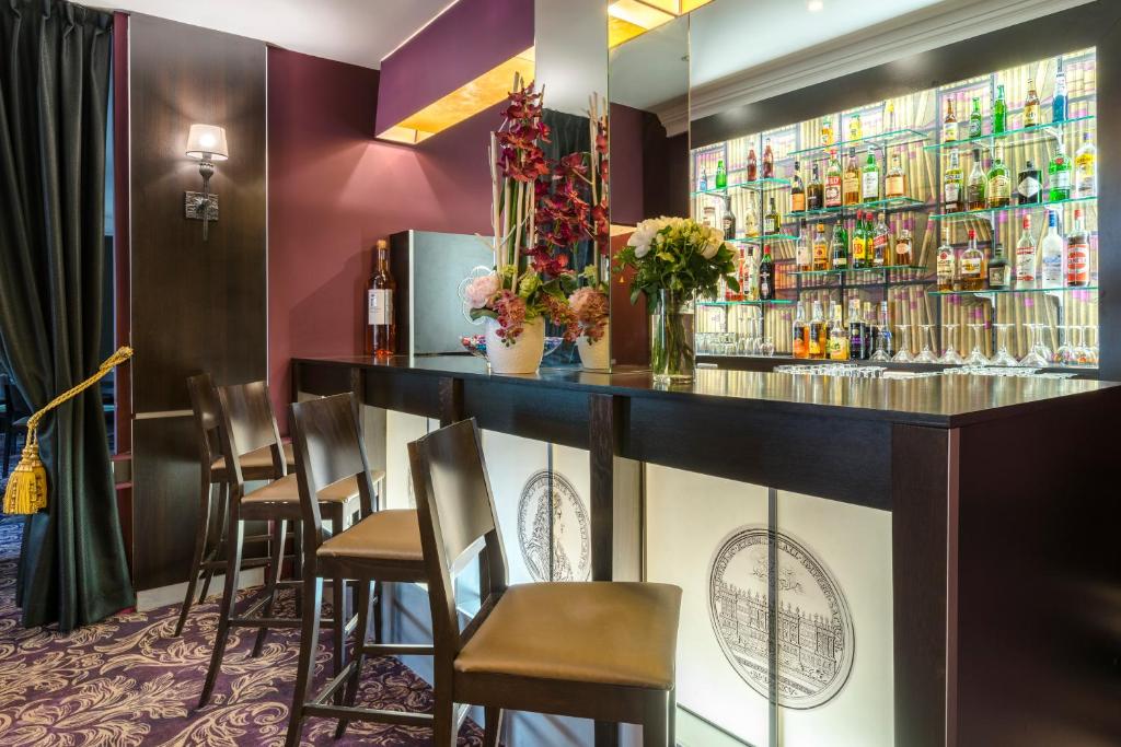 - un bar dans un restaurant avec des chaises et des bouteilles d'alcool dans l'établissement Hôtel Le Versailles, à Versailles
