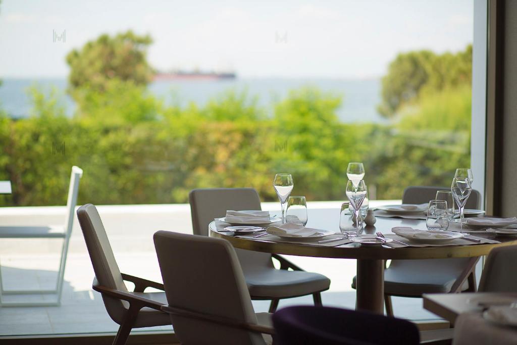 a table with chairs and wine glasses and a window at Makedonia Palace in Thessaloniki