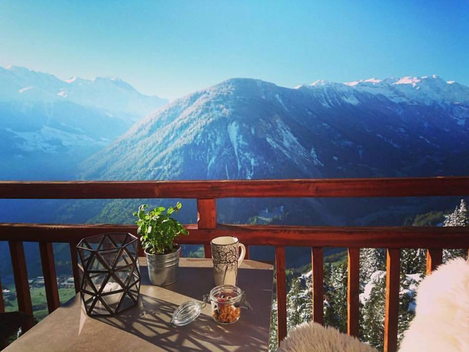 a table on a balcony with a view of a mountain at Hotel Splendide in Champex
