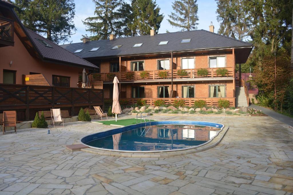 a house with a swimming pool in front of it at Apartamenty Kotwica in Poddąbie