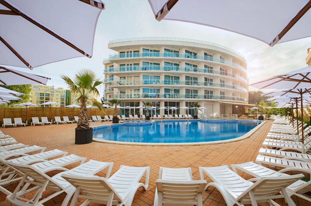 una piscina de hotel con sillas y un edificio en Calypso Hotel - All Incluisve, en Sunny Beach