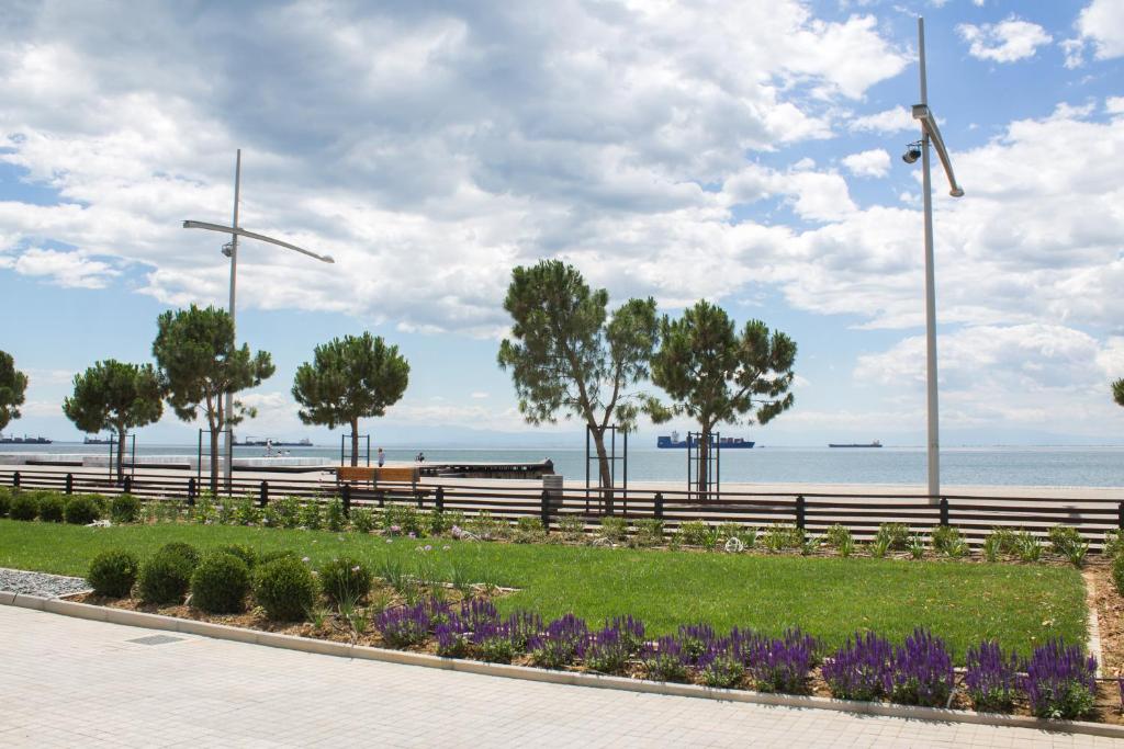 a park with a bench and flowers and wind turbines at Makedonia Palace in Thessaloniki