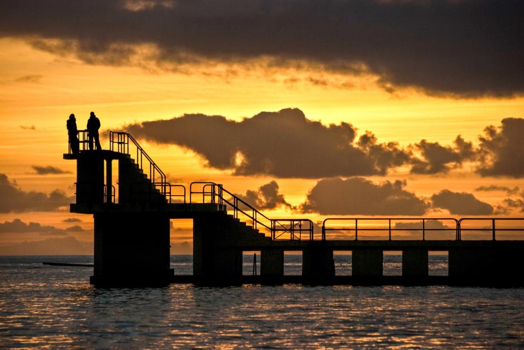two people standing on a pier at sunset at Coiribe House B&SelfBreakfast in Galway