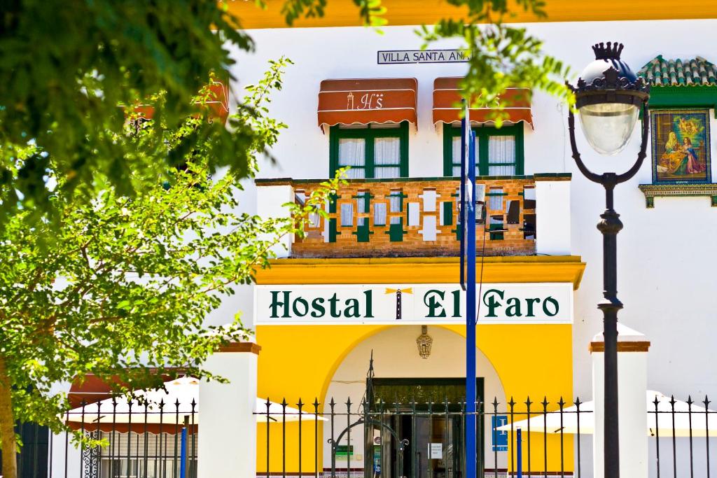 um edifício com uma luz de rua em frente em Hostal El Faro em Chipiona