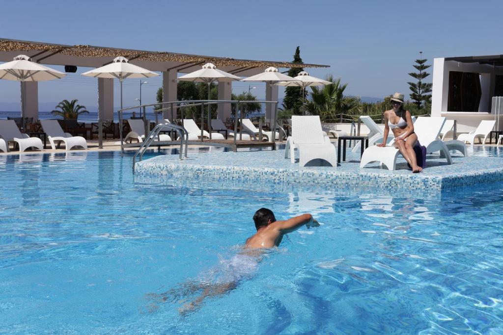 a man in the swimming pool at a resort at Elite City Resort in Kalamata