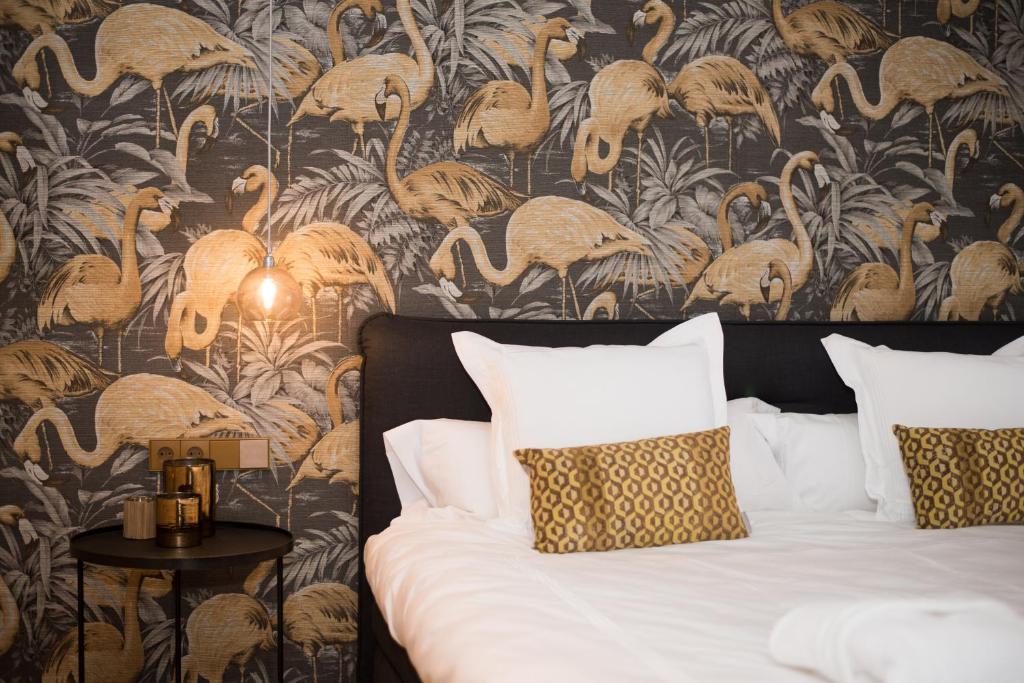 a bedroom with a bed with a wallpaper with flamingos at Hotel 't Keershuys in Den Bosch