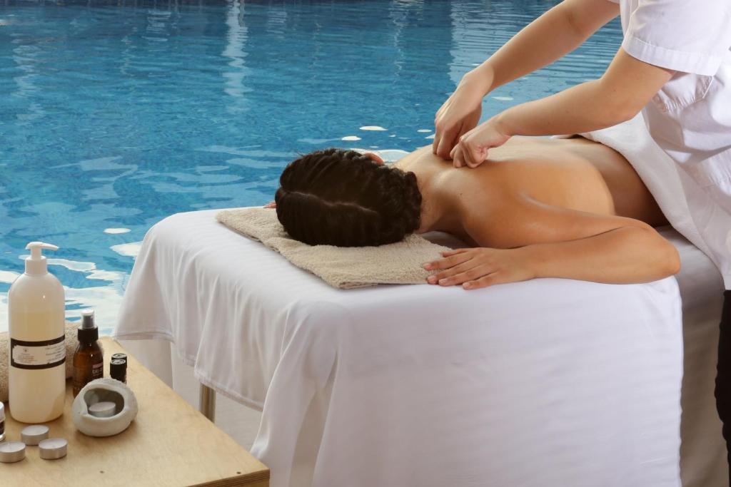 a woman getting a massage in front of a pool at Elite City Resort in Kalamata