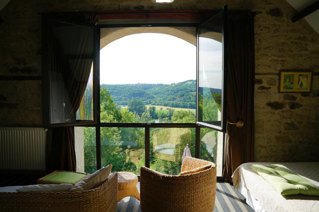 a bedroom with a large window with a view at Hôtel Restaurant Le Mûrier de Viels - Grand Figeac in Causse et Diege