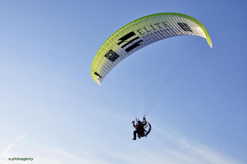 a person riding a parachute in the sky at Elite City Resort in Kalamata