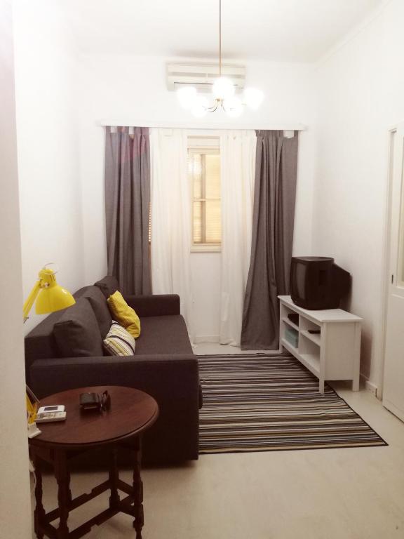 a living room with a couch and a tv at Casa da Madrinha I in Monte Gordo