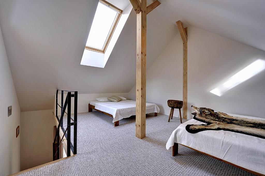 a attic bedroom with two beds and a skylight at Apartmány no.823 in Bublava