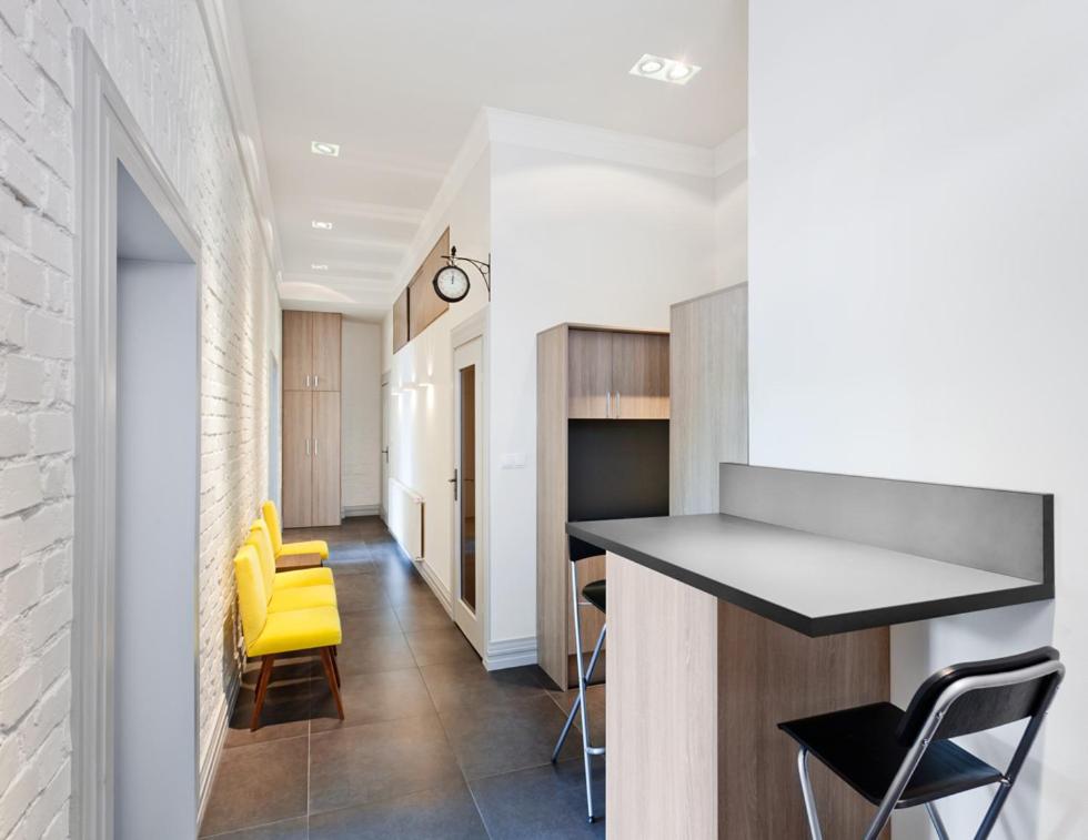 een keuken met een aanrecht en gele stoelen in een kamer bij MoHo S in Wrocław