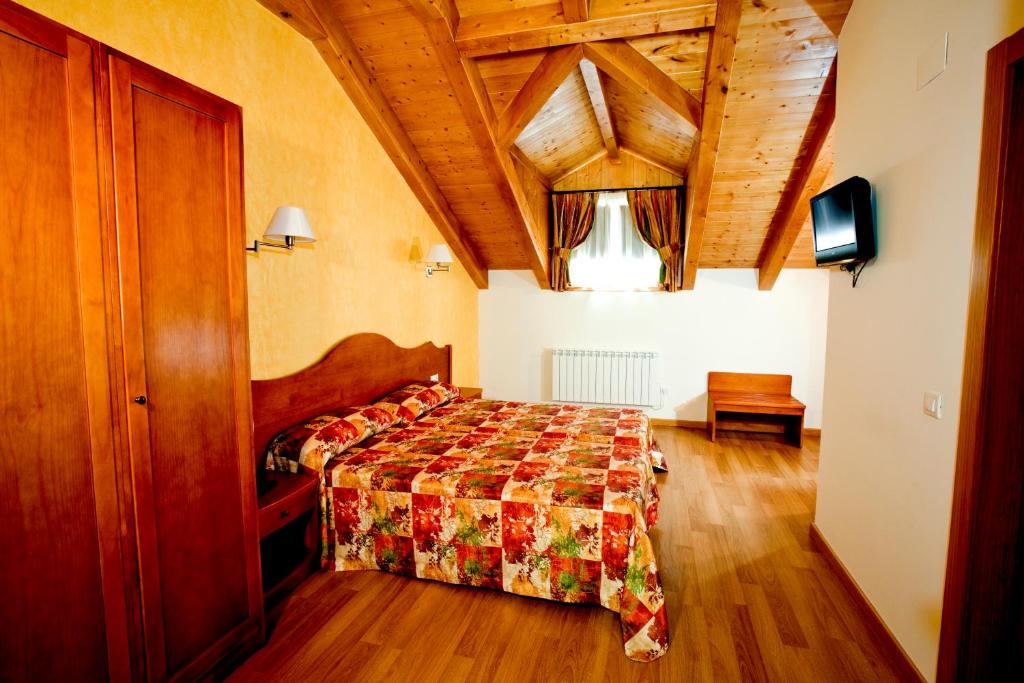 a bedroom with a bed and a dresser at Hotel Montseny in Espúy