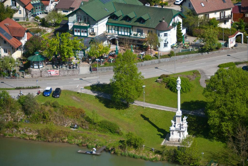 a small town with a statue in the middle of a river at Landhotel Mariensäule in Wernstein am Inn