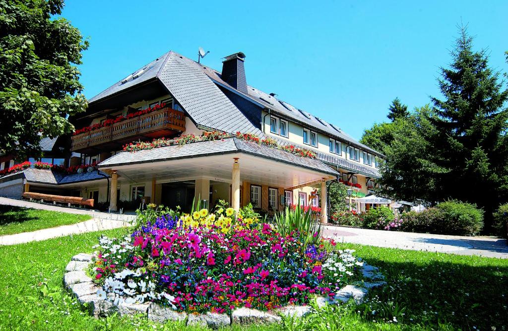 トートモースにあるHotel Schwarzwald-Gasthof Rößleの花の庭が目の前にある家