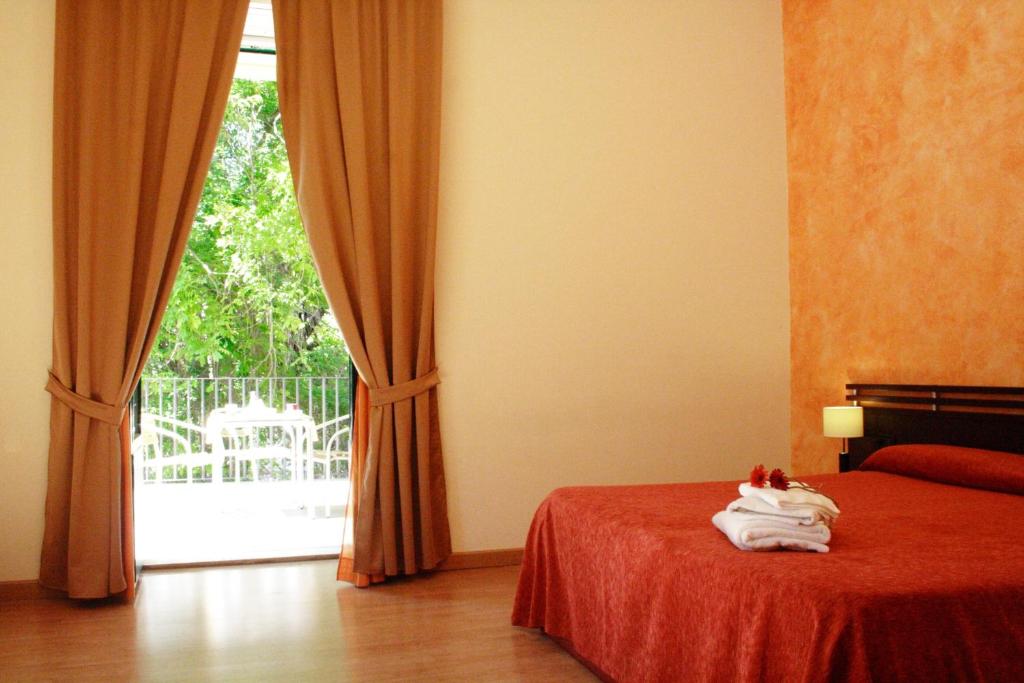 a bedroom with a bed and a large window at San Max Hotel in Catania